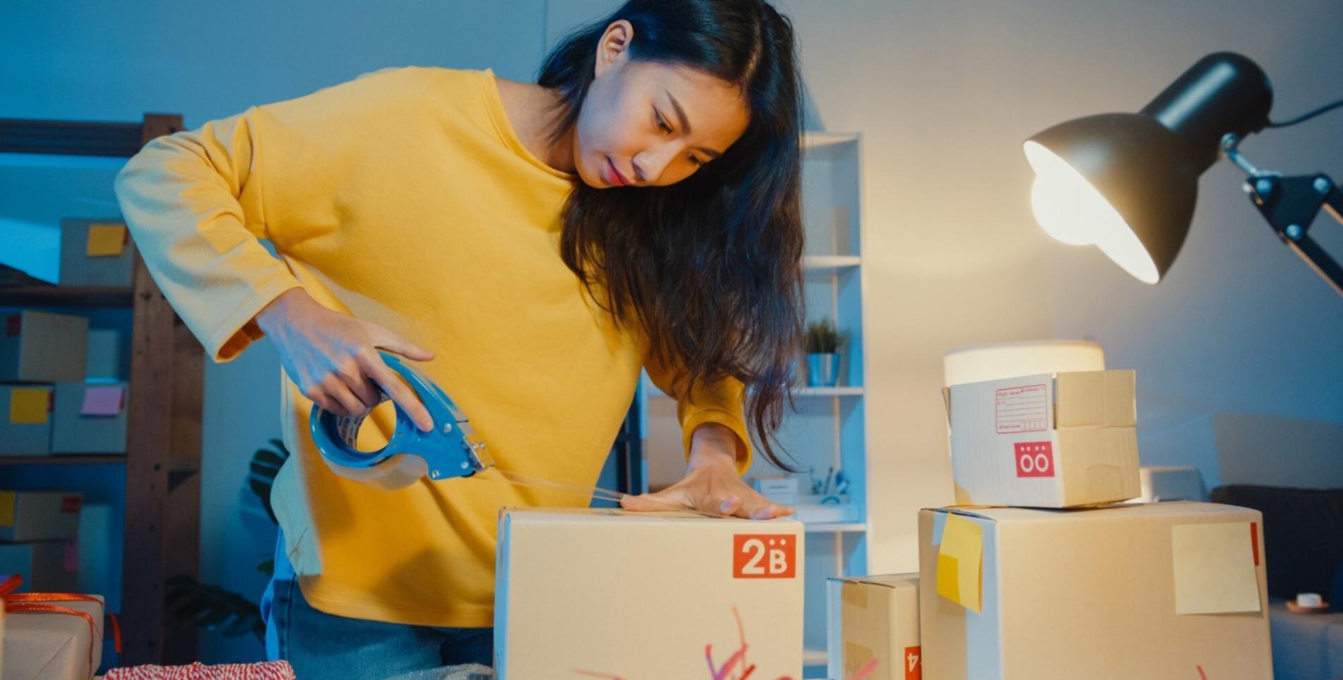 Student reviewing learning materials at desk with laptop and notes